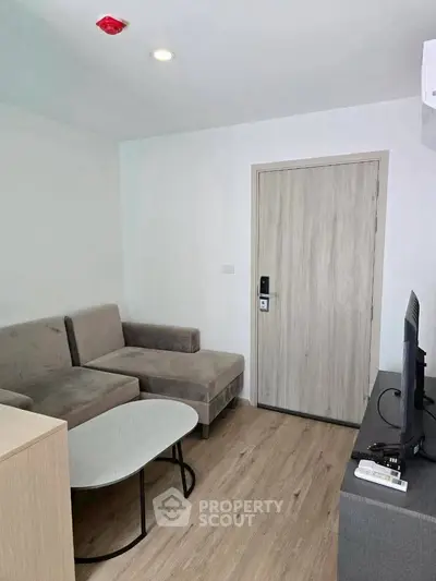 Modern living room with cozy sofa and flat-screen TV, perfect for relaxation.