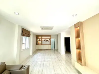 Spacious modern living room with elegant built-in shelves and ample natural light.