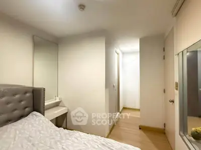 Cozy bedroom with modern decor and natural light, featuring a comfortable bed and sleek wooden flooring.