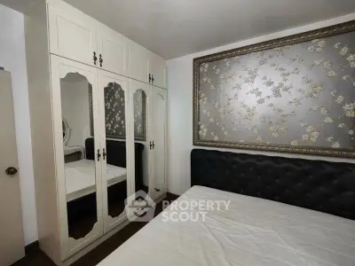 Cozy bedroom with elegant mirrored wardrobe and stylish floral wallpaper