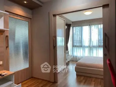 Modern bedroom with wooden flooring and large windows offering natural light.