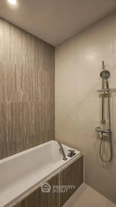 Modern bathroom with elegant tile design and sleek shower fixtures.