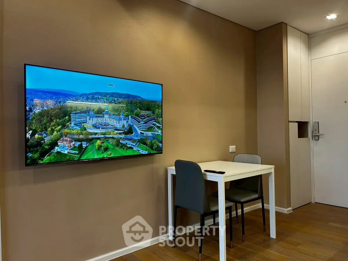 Modern living room with wall-mounted TV and dining table, showcasing elegant interior design.