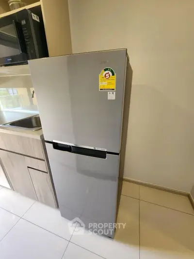 Modern kitchen with sleek stainless steel refrigerator and built-in microwave.