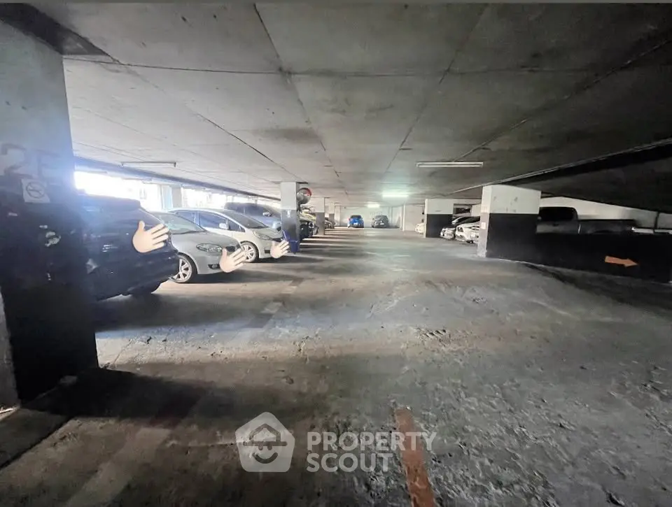 Spacious underground parking area with ample lighting and multiple parked cars.