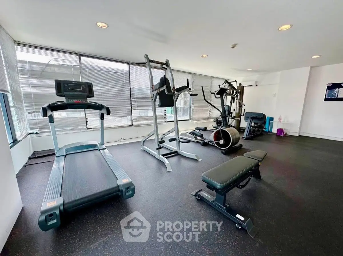 Modern gym with state-of-the-art equipment and large windows for natural light.