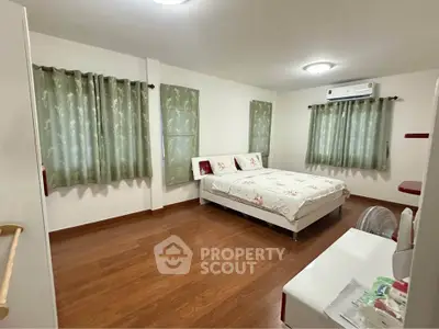 Spacious bedroom with elegant decor and wooden flooring