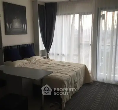 Cozy bedroom with large windows and elegant curtains, offering a serene and inviting atmosphere.