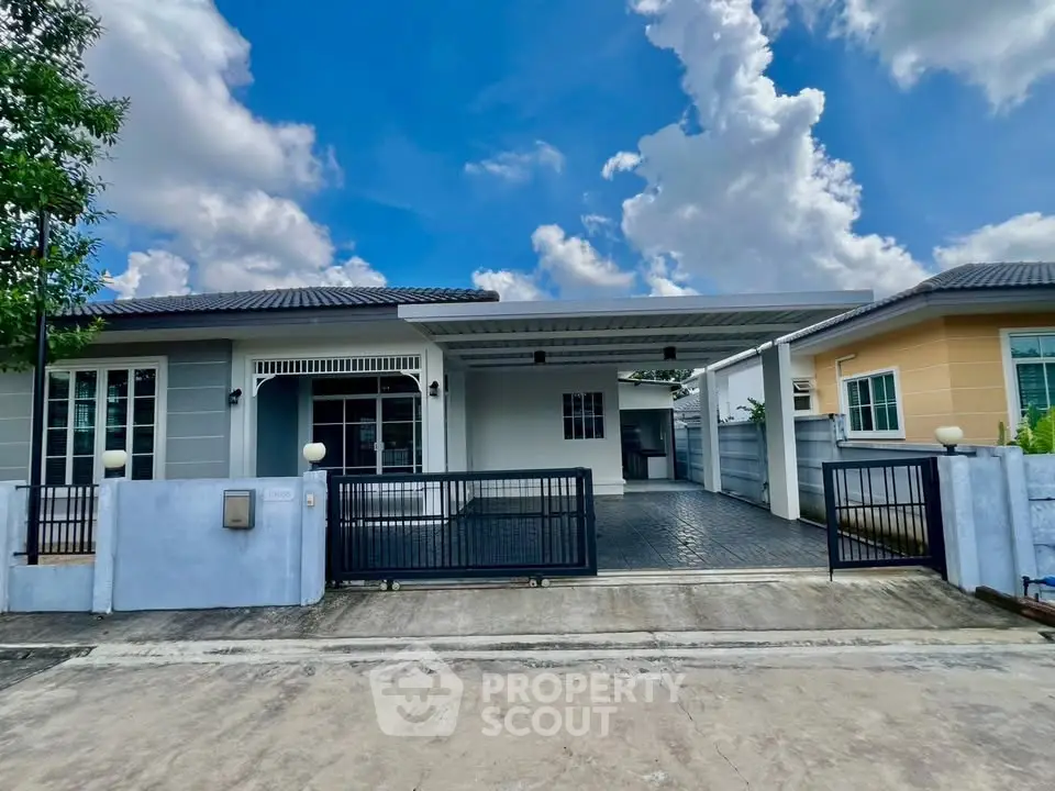 Charming single-story home with spacious driveway and modern exterior design under a clear blue sky.