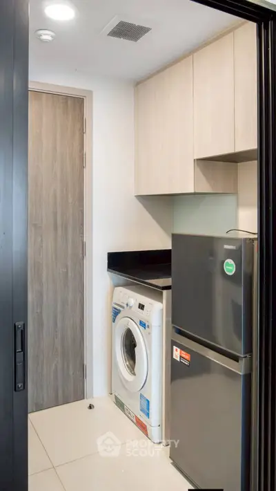 Modern kitchen with washing machine and fridge in compact layout