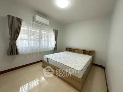 Spacious bedroom with natural light and modern furnishings