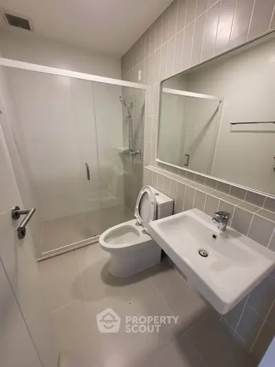 Modern bathroom with glass shower and sleek fixtures in a contemporary apartment.