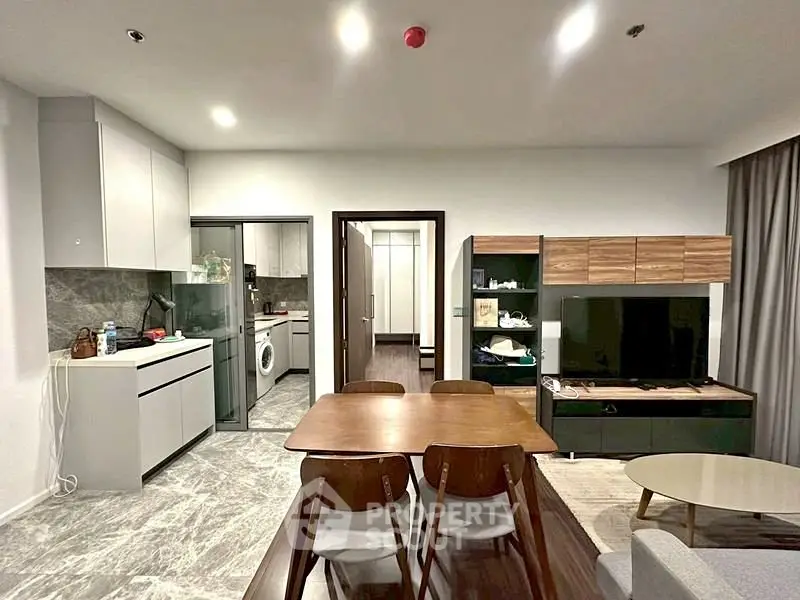 Modern open-plan living room with dining area and sleek kitchen design