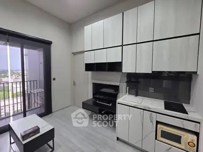 Modern kitchen with sleek cabinetry and balcony view in stylish apartment