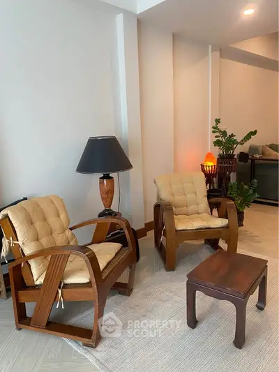 Cozy living room with vintage wooden chairs and warm lighting, perfect for relaxation.