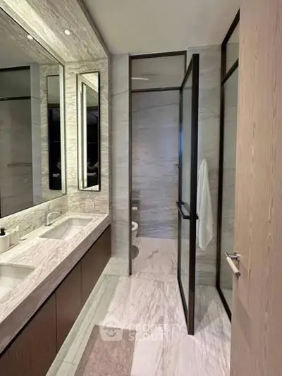 Luxurious modern bathroom with marble finishes and dual sinks.