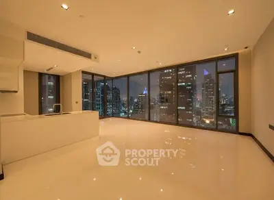 Spacious modern living room with stunning city view and floor-to-ceiling windows.
