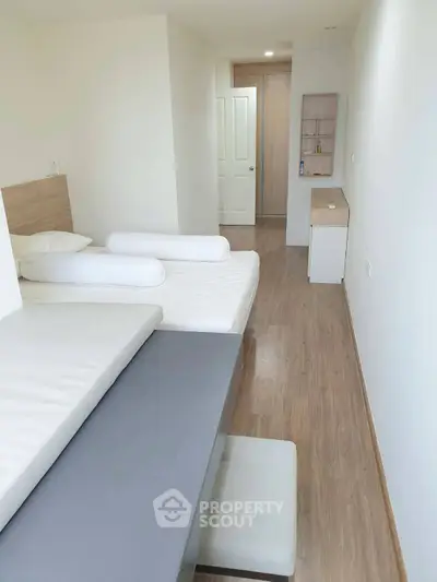 Modern minimalist bedroom with wooden flooring and sleek furniture