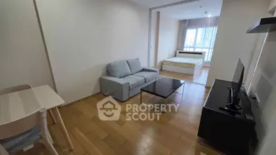 Modern studio apartment with open layout, featuring cozy living area and bedroom with natural light.