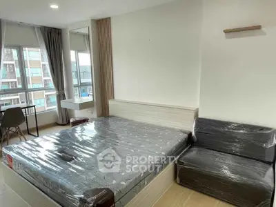 Modern bedroom with large windows and natural light in a stylish apartment.