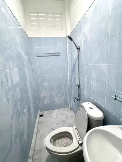 Compact bathroom with blue tiles and modern fixtures