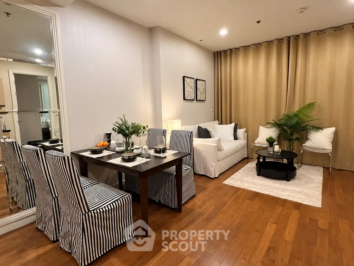 Stylish living room with dining area, hardwood floors, and elegant decor in modern apartment.