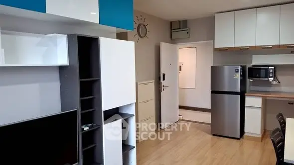 Modern apartment interior with open kitchen and stylish storage solutions.