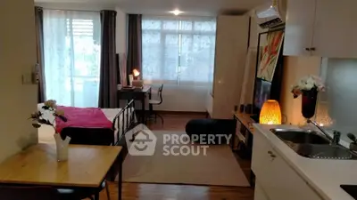 Modern studio apartment with open layout, featuring cozy living area, stylish kitchen, and natural light.