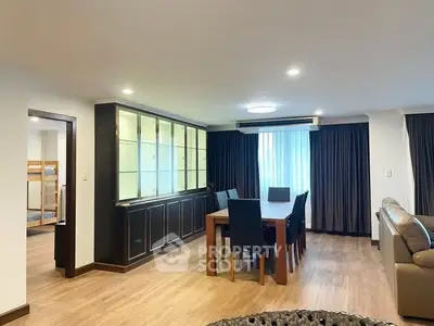 Spacious modern living room with elegant dining area and natural light.