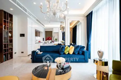 Luxurious modern living room with elegant chandelier and plush blue sofa, perfect for sophisticated living.