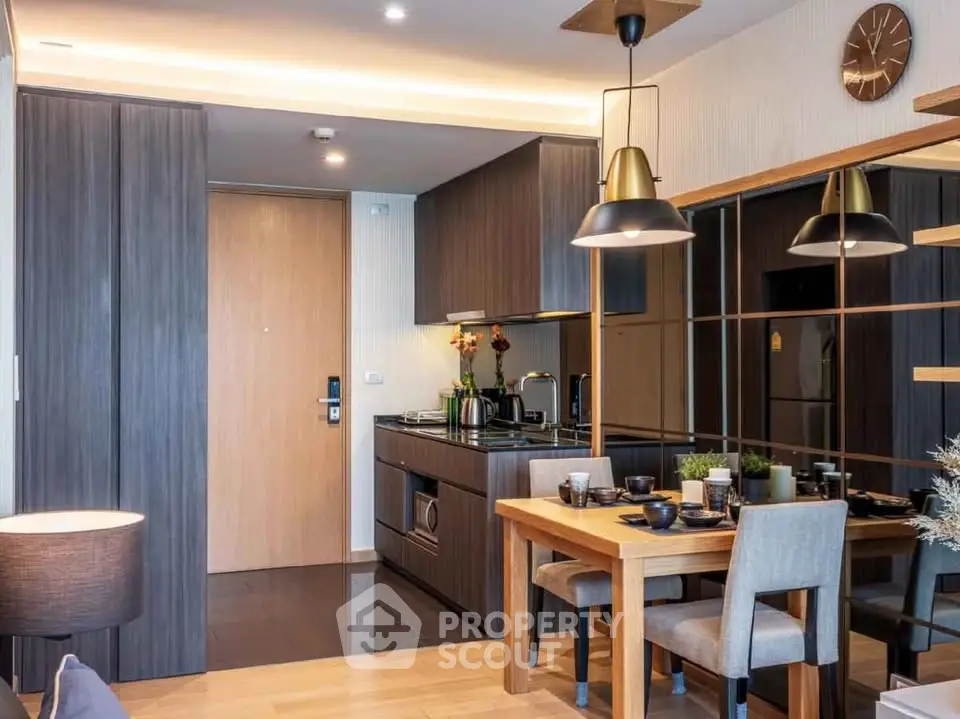 Modern kitchen and dining area with sleek cabinetry and stylish lighting in a contemporary apartment.