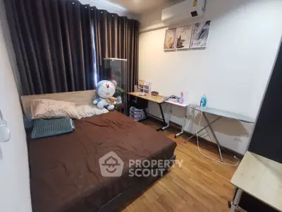 Cozy bedroom with wooden flooring, modern decor, and ample natural light.