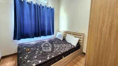 Cozy bedroom with wooden flooring and stylish bed, perfect for relaxation.