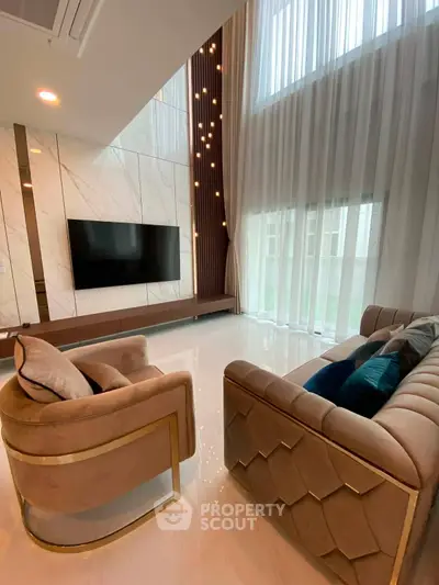 Luxurious living room with high ceilings, elegant chandelier, and plush seating in a modern home.