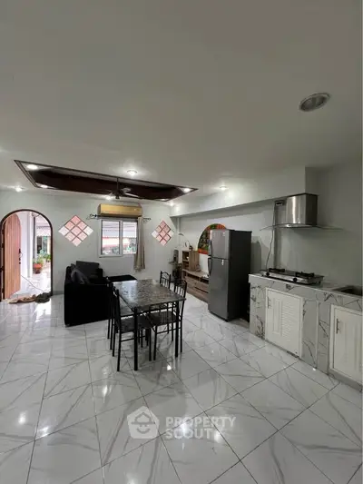 Spacious open-layout kitchen and living area with modern appliances and elegant marble flooring.