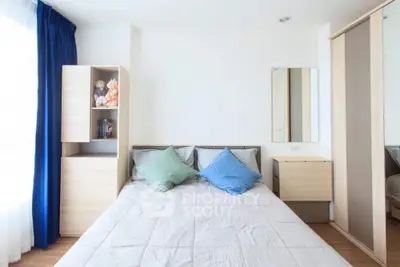 Bright and airy bedroom with a large bed, mirrored wardrobe, and a cozy reading nook, perfect for modern living.