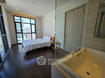 Modern bedroom with city view and luxurious bathtub, featuring floor-to-ceiling windows and elegant wooden flooring.
