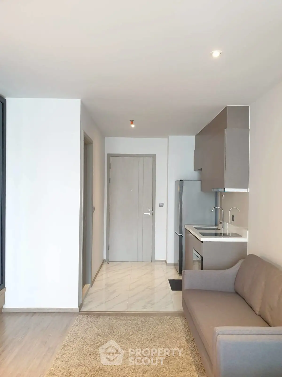 Modern apartment interior with compact kitchen and cozy living area, perfect for urban living.