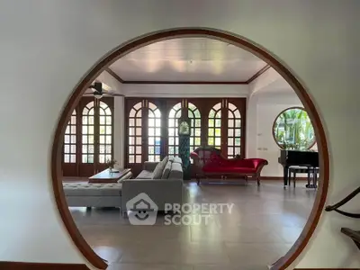 Elegant living room with circular entrance, stylish furniture, and grand piano, perfect for luxury living.