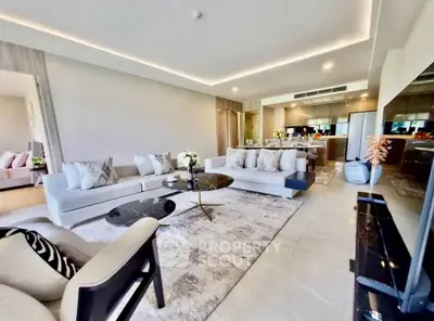 Luxurious open-plan living room with modern decor and sleek kitchen