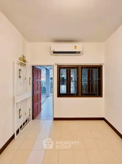 Bright and airy room with air conditioning and tiled flooring, perfect for a cozy living space.