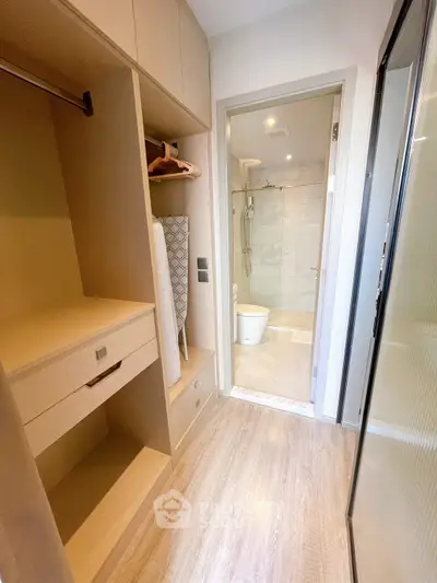Modern bathroom with sleek design and adjacent storage space in a contemporary apartment.