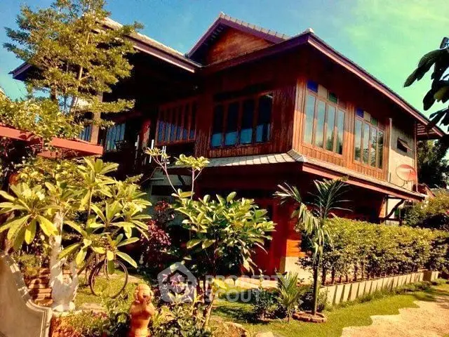Stunning traditional wooden house with lush garden and vibrant greenery, perfect for serene living.
