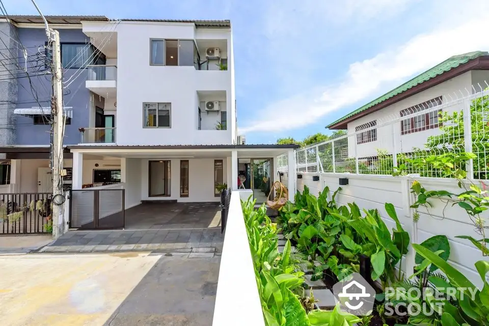 Modern townhouse with spacious driveway and lush garden, perfect for family living in a vibrant neighborhood.