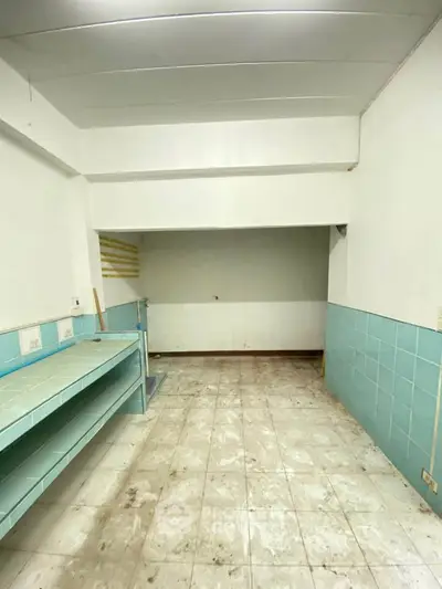 Spacious basement storage area with tiled walls and floor, ideal for extra storage needs.