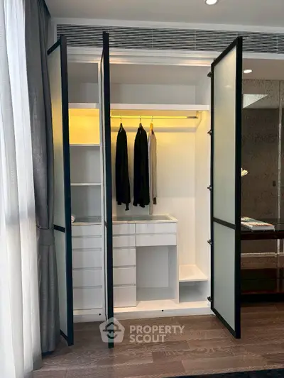 Modern wardrobe with sleek design and ample storage space in a stylish bedroom setting.