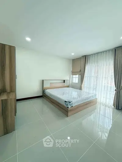 Spacious modern bedroom with large windows and sleek tile flooring
