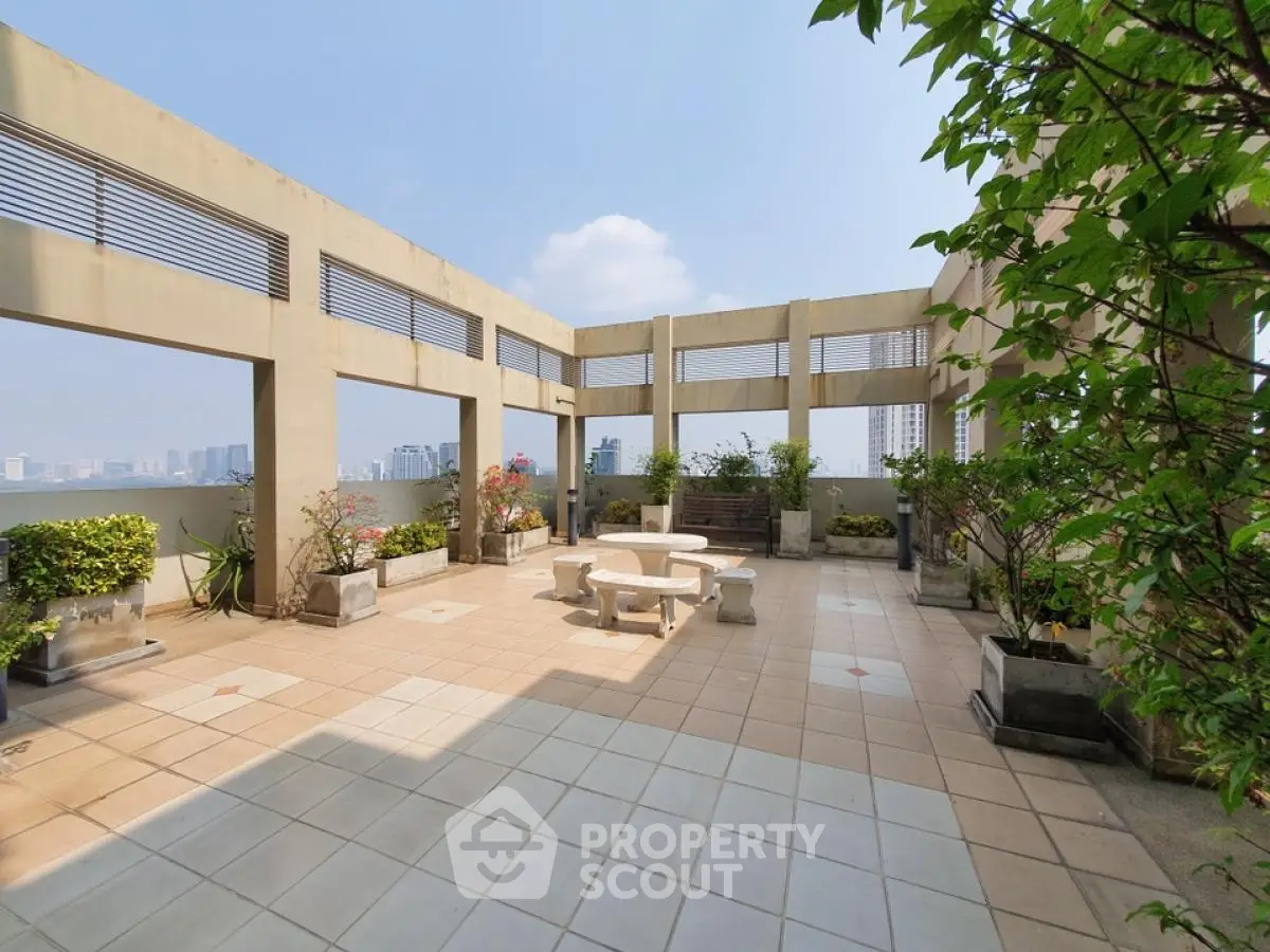 Spacious rooftop terrace with city skyline view and elegant seating area