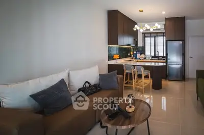 Modern open-layout living room and kitchen with stylish furniture and lighting.