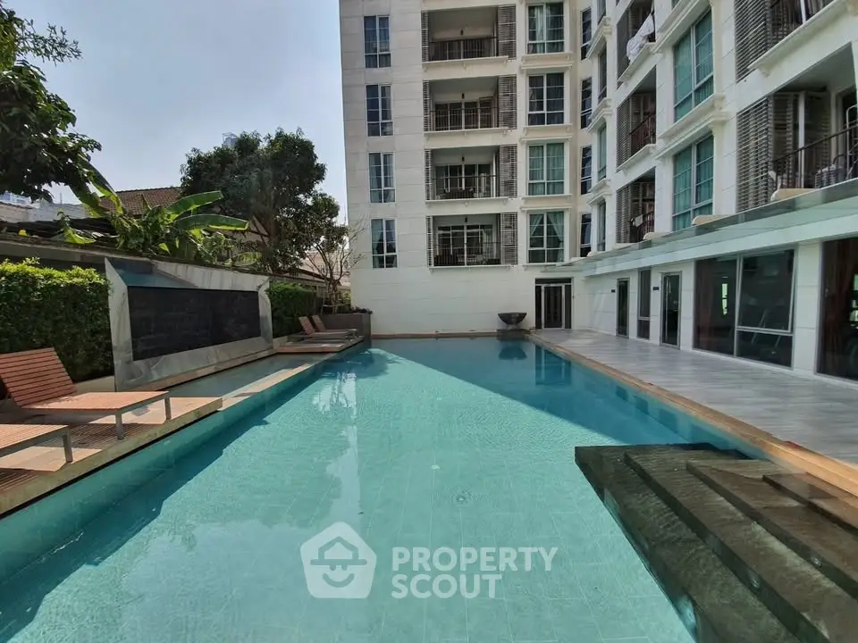 Luxurious apartment building with a stunning outdoor pool and modern design.